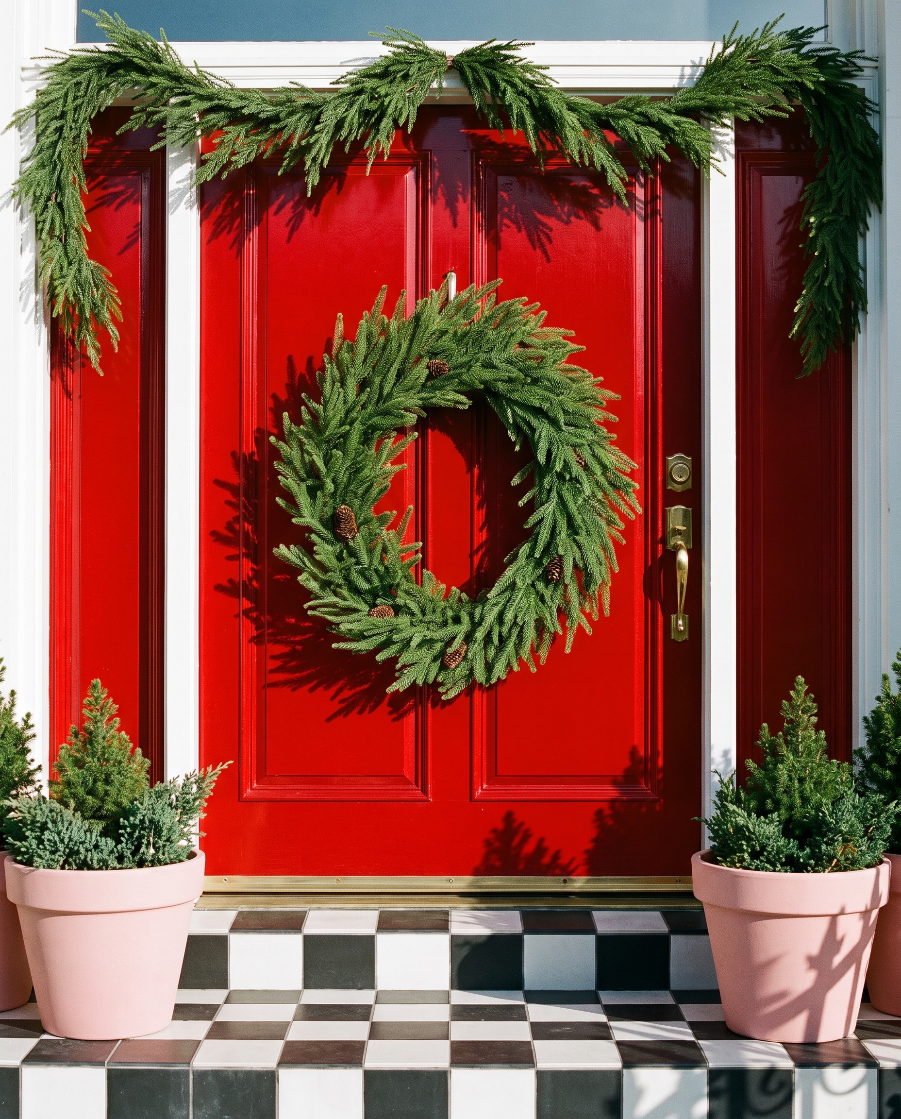 Pine wreath and garland on a red front door